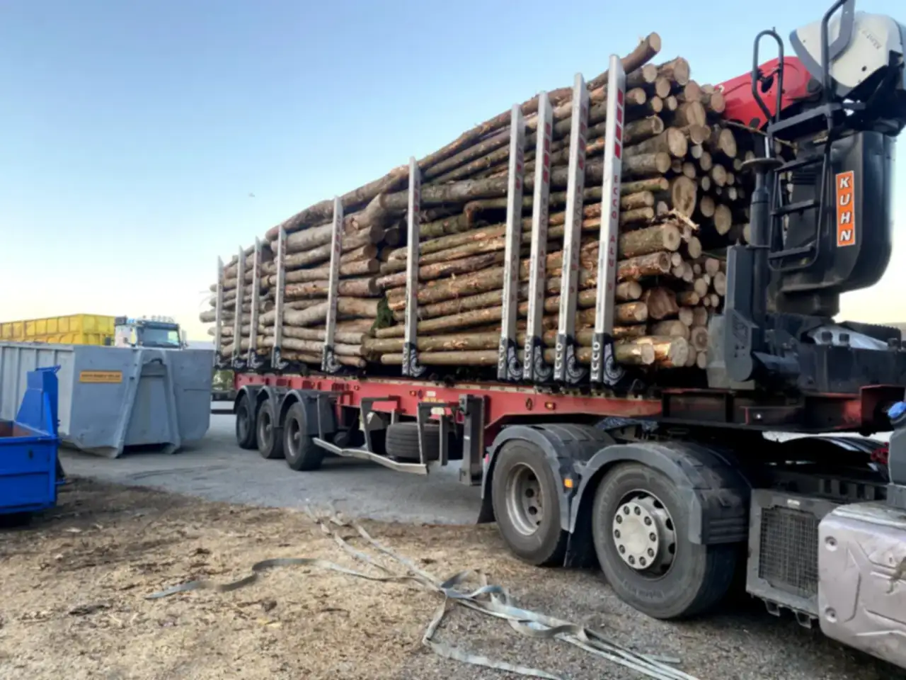 Nákladní auto s hydraulickou rukou a návěsem naloženým kmeny